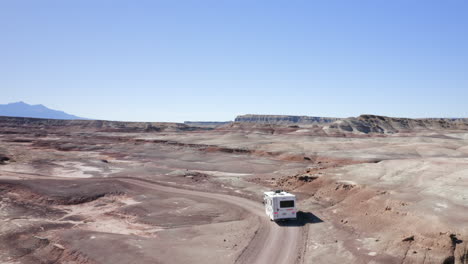 Aerial-shot-following-an-RV-driving-off-road-through-the-Utah-desert-on-an-american-roadtrip