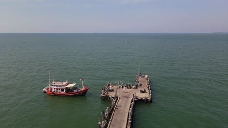 Aerial-footage-sliding-fast-towards-the-right-revealing-the-Pattaya-Fishing-Dock-and-a-fishing-boat,-Pattaya,-Thailand