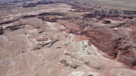 Long-aerial-shot-following-an-RV-off-road-through-the-Utah-desert-on-American-roadtrip