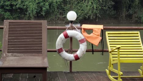 Zwei-Liegen-Auf-Dem-Deck-Eines-Schwimmenden-Hausboots,-Im-Hintergrund-Der-Fluss-Khwae,-Der-In-Kanchanaburi,-Thailand,-Vorbeifließt