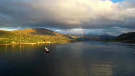 Eine-Super-Coole-Filmische-Hd-aufnahme-Des-Wunderschönen-Loch-Broom-Ullapool,-Während-Die-Sonne-über-Den-Sommerinseln-Im-Hochland-Der-Nordwestküste-Schottlands-Mit-Einem-Boot-Auf-Der-Schönen-Insel-Untergeht