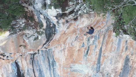 Sport-climber-rappelling-down-a-mountain-wall