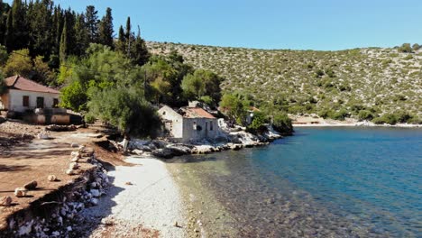 View-Along-The-Coast-With-Old-Houses-At-Agia-Sofia-Beach-In-Kefalonia,-Greece---drone-shot