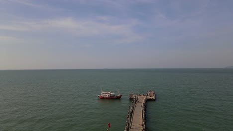 Descending-aerial-footage-of-the-Pattaya-Fishing-Dock-revealing-fishing-boats-on-the-left-and-the-stretch-of-the-pier,-Pattaya,-Thailand
