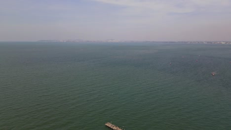 Umgekehrte-Luftaufnahmen-Des-Meeres-In-Pattaya-Mit-Fischerbooten-Und-Dann-Das-Fischerdock-Von-Pattaya-Mit-Einer-Bootsanlegestelle,-Pattaya,-Thailand