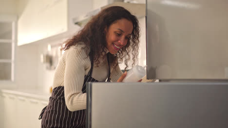 Latin-woman-open-fridge-or-refrigerator-in-kitchen