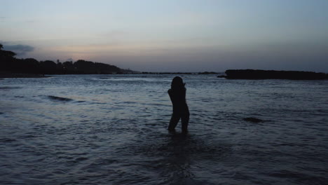 Silhouette-of-Female-Tourist-Wading-in-Ocean-Water-in-Dominican-Republic