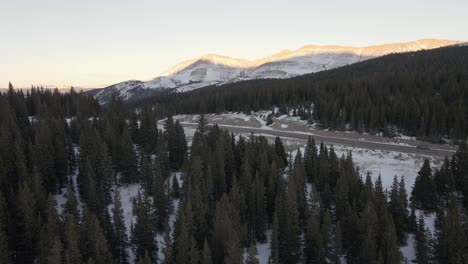 Aerial-pan-along-North-Star-Mountain-towards-a-mountain-pass-at-sunset,-with-Hoosier-Ridge-in-the-distance
