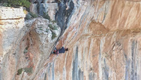 Sport-climber-ascending-a-overhang-mountain-wall