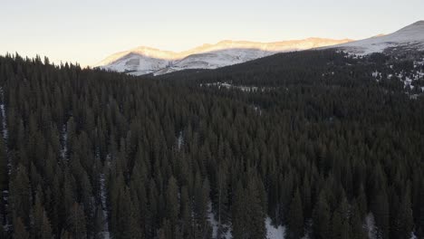 Aerial-flight-along-North-Star-Mountain-towards-a-mountain-pass-at-sunset,-with-Hoosier-Ridge-in-the-distance