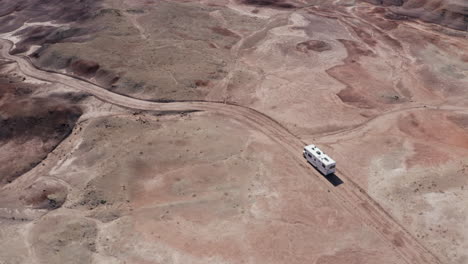 An-aerial-shot-of-an-Rv-driving-off-road-through-the-Utah-desert-on-an-American-roadtrip