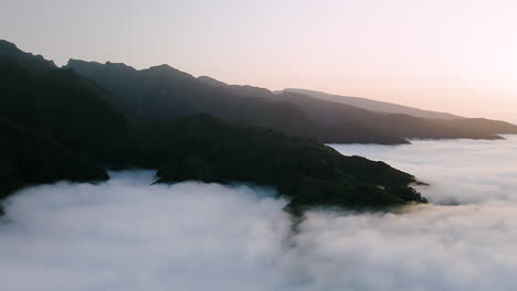 Madeira-mountains-high-over-the-sky-with-sea-of-clouds-at-sunset---aerial-shot