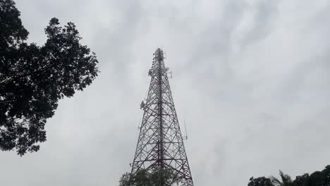 Looking-Up-At-Telecommunications-Tower-Against-Grey-Clouds