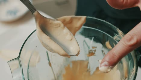 Close-up-on-spoon,-chef-checks-consistency-of-homemade-delicious-mayonnaise