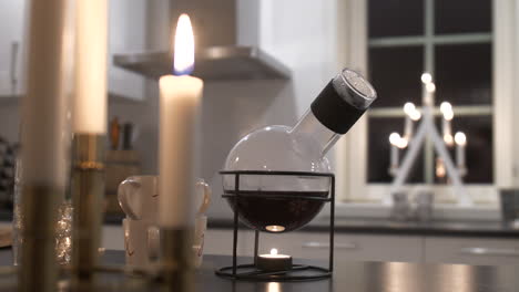 Pan-of-traditional-mulled-wine-bottle-and-candles-on-table,-Christmas