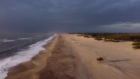 Aerial-view-of-beautiful-empty-sandy-beach-and-Ocean-waves-with-dramatic-dark-clouds-at-sky,4K