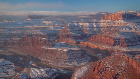 Time-lapse,-clouds-and-mist-above-snow-capped-red-rock-formations-in-Utah-desert-USA