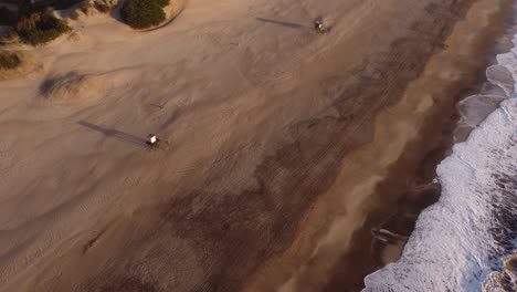 Aerial-orbit-shot-showing-Lifeward-Stands-on-sandy-beach-during-beautiful-sunrise-light-in-the-morning---Top-Down-shot-of-Mar-de-las-Pampas,Argentina