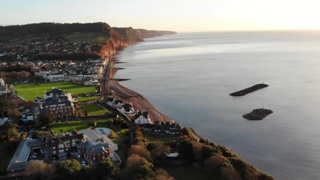Aerial-shot-of-Sidmouth-Town-Devon-England-at-sunrise-bathed-in-golden-sunshine