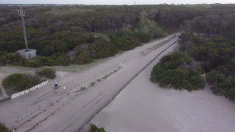 Drohnen-Tracking-Aufnahme-Eines-Motorradfahrens-Auf-Sandigem-Weg-Neben-Waldbäumen-In-Argentinien