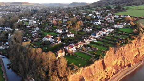 Aerial-forward-shot-over-houses-on-the-cliff-edge-at-Sidmouth-South-West-England-at-sunrise