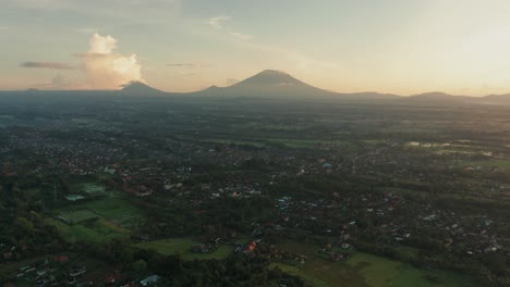 Perfect-golden-sunlight-shining-on-foothill-of-Mount-Agung-and-Abang-at-Ubud,-aerial