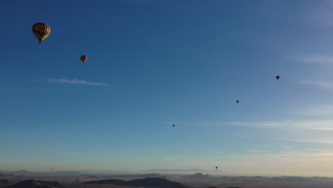Hot-air-balloons-flying-high-in-the-sky-viewed-from-a-nearby-drone