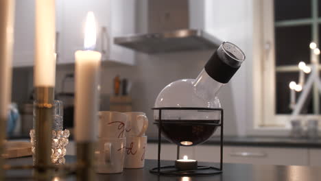 Wine-is-being-heated-in-beautiful-jug-by-candle-during-Christmas-time,-motion-view