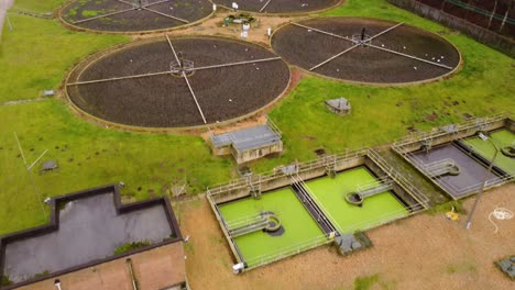 Forest-side-sewage-wastewater-treatment-plant-in-Thetford,-Norfolk---aerial-drone-forward-flight-shot