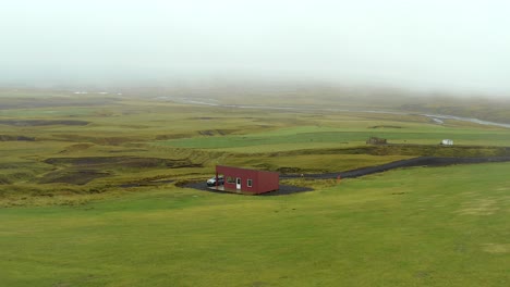 Red-cabin-travel-destination-in-the-middle-of-Iceland-humid-green-environment