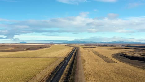 Luftaufnahme-Eines-Fahrzeugs,-Das-Durch-Eine-Zwei-Wege-Autobahn-In-Island-Fährt,-Mit-Erstaunlichem-Landschaftshintergrund