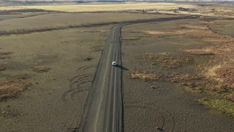 Drunk-driver-driving-on-a-dirt-road,-drowsy-driver-going-off-road,-aerial-back-view