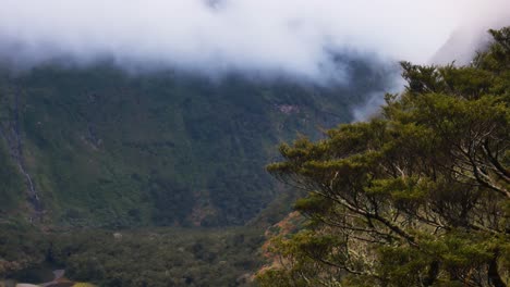 Toma-Amplia-De-Montañas-Verdes-Y-Valle-Rural-Con-Nubes-Voladoras-Entre-Cumbres-Durante-El-Día-Ventoso