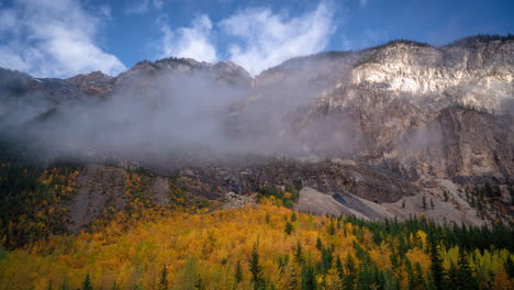 Time-lapse,-autumn-season-in-high-mountains,-yellow-aspen-forest-in-valley-under-peaks-and-clouds