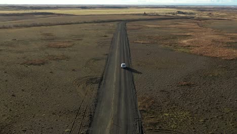 View-from-above-car-driving-along-Dark-sand-road,-Icelandic-Landscape