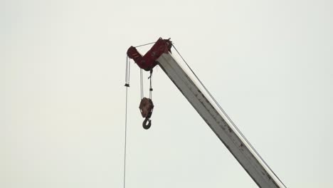 A-close-up-shot-of-the-lifting-hook-of-a-tall-heavy-duty-mobile-crane-on-a-construction-site