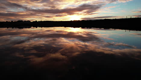 Fliegen-über-Wasser-Mit-Erstaunlicher-Sonnenaufgang-Spiegelreflexion,-Drohne-Luftaufnahme-Der-Bucht-In-Galway,-Irland
