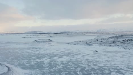 Drohnenflug-über-Den-Zugefrorenen-My-Vatn-See-Und-Den-Schneebedeckten-Vulkankrater-An-Kalten-Wintertagen---Atemberaubende-Winterszene-Von-Nordisland