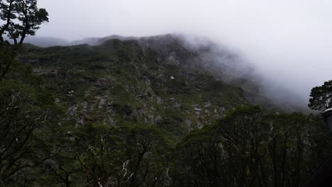 Static-wide-shot-of-flying-clouds-and-fog-between-greened-mountains-at-Milford-Track,New-Zealand