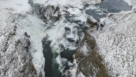 Slow-drone-birds-eye-shot-of-icelandic-Reykjafoss-Waterfall-in-Winter---Powerful-water-cascade-in-Iceland