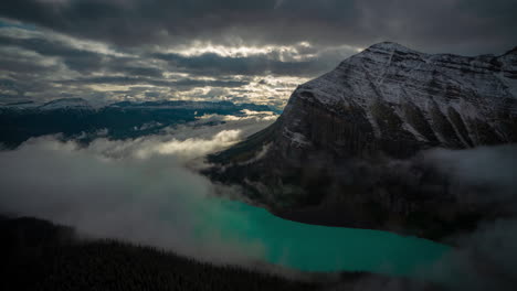Lapso-De-Tiempo-De-Un-Magnífico-Paisaje-Atmosférico-Sobre-El-Lago-Glacial-Y-La-Montaña-Cubierta-De-Nieve,-Inversiones-De-Nubes-Y-Niebla,-Lago-Louise,-Parque-Nacional-Banff-Alberta,-Canadá
