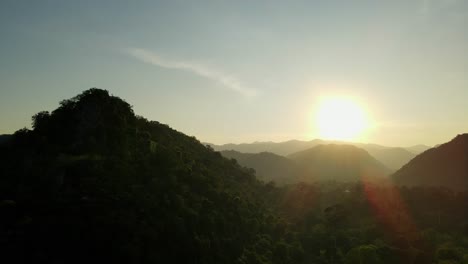 Aerial-footage-of-this-progressing-sunset-creating-silhouettes-of-the-mountains-in-the-horizon-and-the-hills-up-front-in-Khao-Yai-National-Park,-Thailand