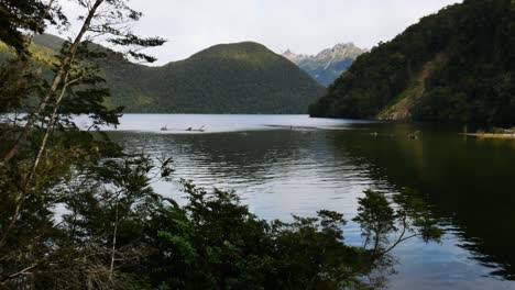 Idyllischer-See,-Umgeben-Von-Bewachsenen-Bergen-Bei-Hellem-Himmel-In-Neuseeland---Weite-Aufnahme