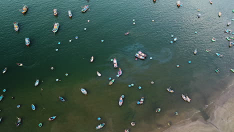 Local-fisherman-boats-of-Vietnam-leaking-oil-into-ocean-water,-aerial-orbit-shot