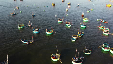 Aerial,-traditional-round-Vietnamese-fishing-boats-moored,-floating-on-ocean
