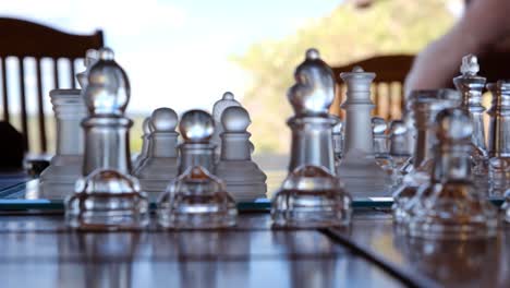 Chess-game-timelapse-with-chessboard-close-up,-playing-an-outdoor-match-with-transparent-chess-pieces