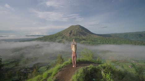 Yoga-woman-practicing-Upward-Salute,-Raised-Hands-Pose-at-Kayupadi-viewpoint,-Mount-Batur