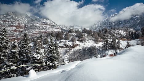 Time-lapse,-Idyllic-White-Winter-Landscape-in-Mountains-on-Sunny-Day,-Clouds-and-Snow-Capped-Hills-and-Peaks