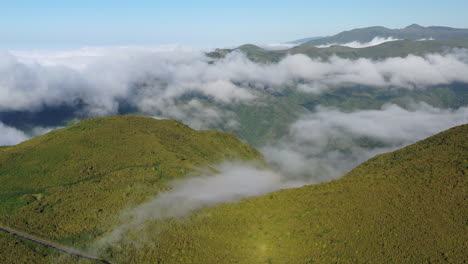 Aerial-Panorama,-Madeira-Island-Ridge-with-Lush-Green-Vegetation-and-Low-Clouds-on-Sunny-Summer-Day,-Drone-Shot