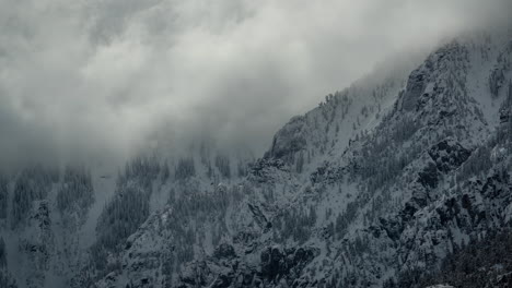 Timelapse,-dark-clouds-above-snow-capped-hills-in-a-cold-white-winter-landscape